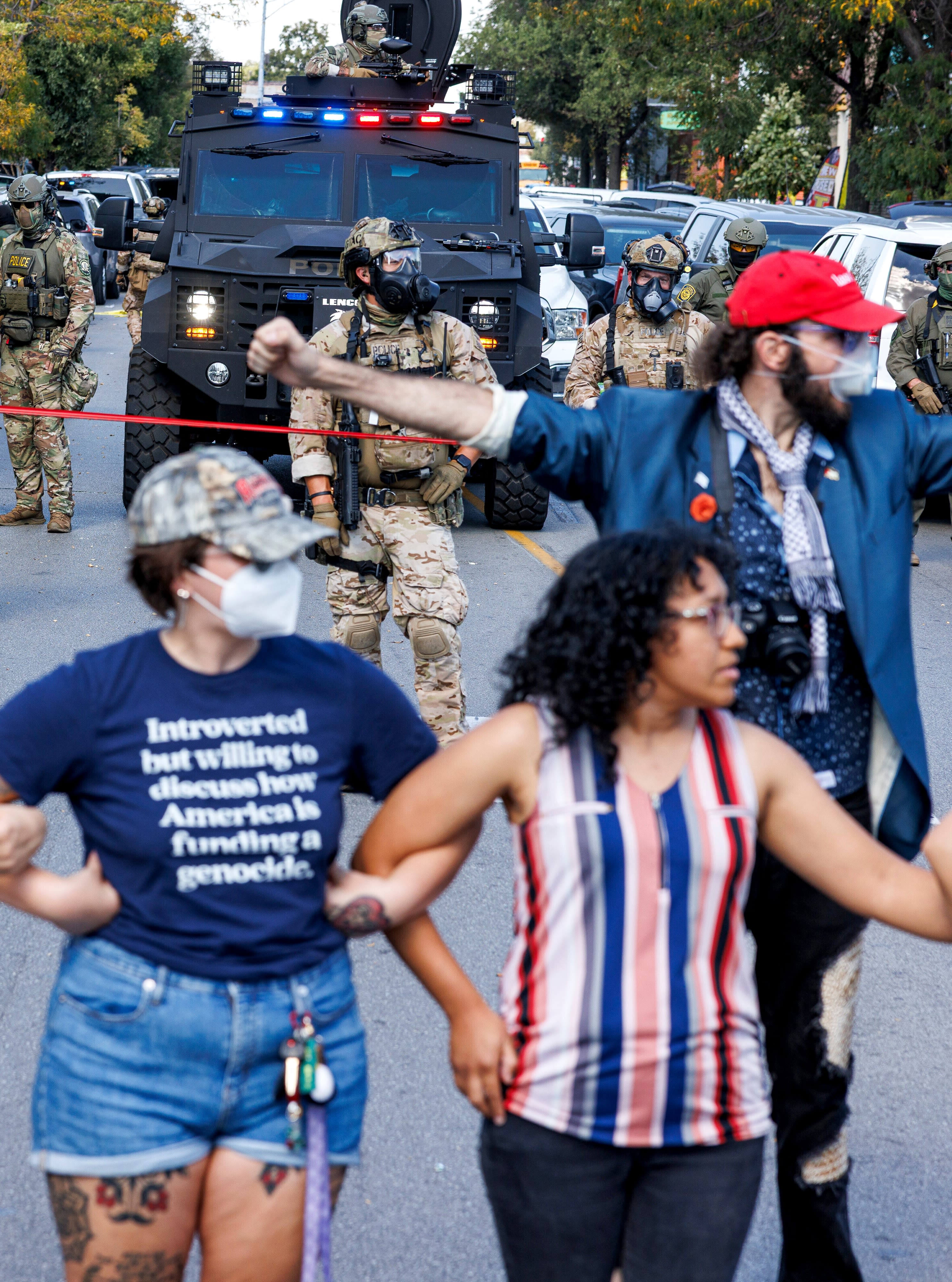 Protesters create a line to maintain distance from ICE officers in the Brighton Park neighborhood on Oct. 4, 2025 after learning U.S. Border Patrol shot a woman. (Anthony Vazquez/Chicago Sun-Times via AP)