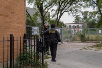 Security officers stand outside of the building at 7500 South Shore Drive in Chicago that was raided by federal agents on Sept. 30. (AP Photo/Erin Hooley)